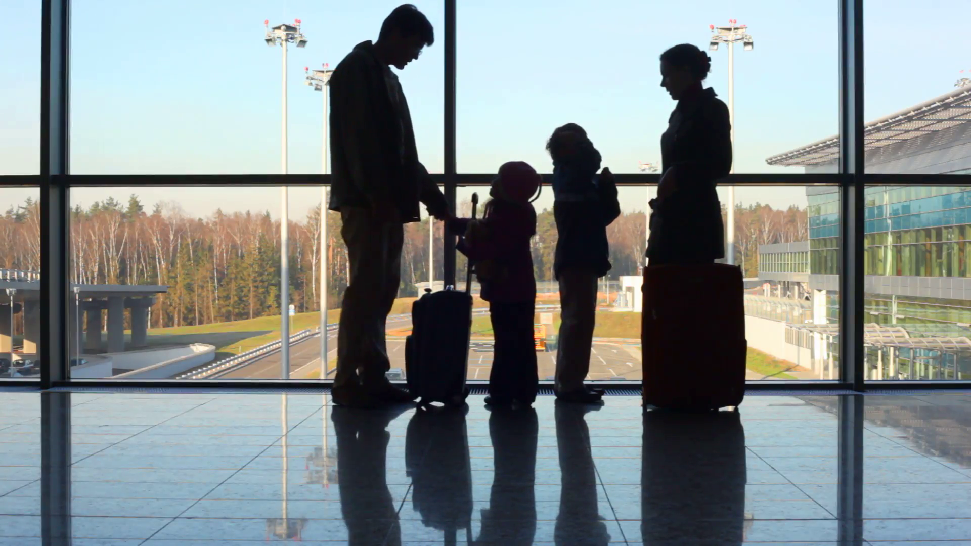 family-stands-against-window-at-airport_7khajhud__F0000